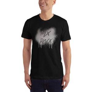 以下が含まれることがあります： 「MX ROCK」と書いてあるグレーのスプレーペイントのデザインが施された黒いTシャツです。