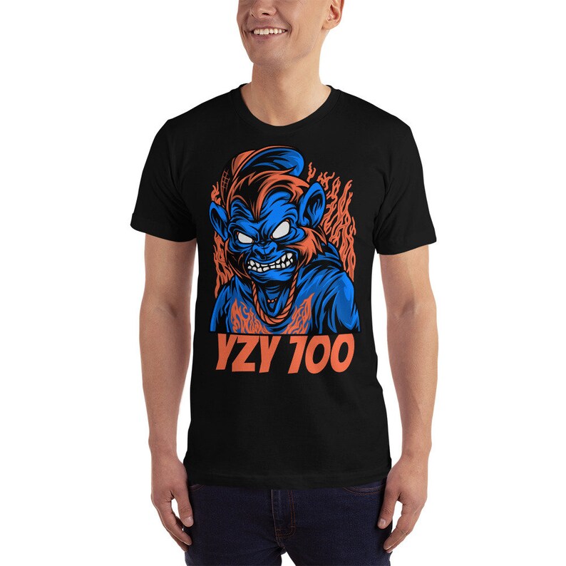 May include: Black t-shirt with a blue and orange graphic of a cartoon monkey with flames behind it. The text "YZY 700" is printed in orange below the graphic.