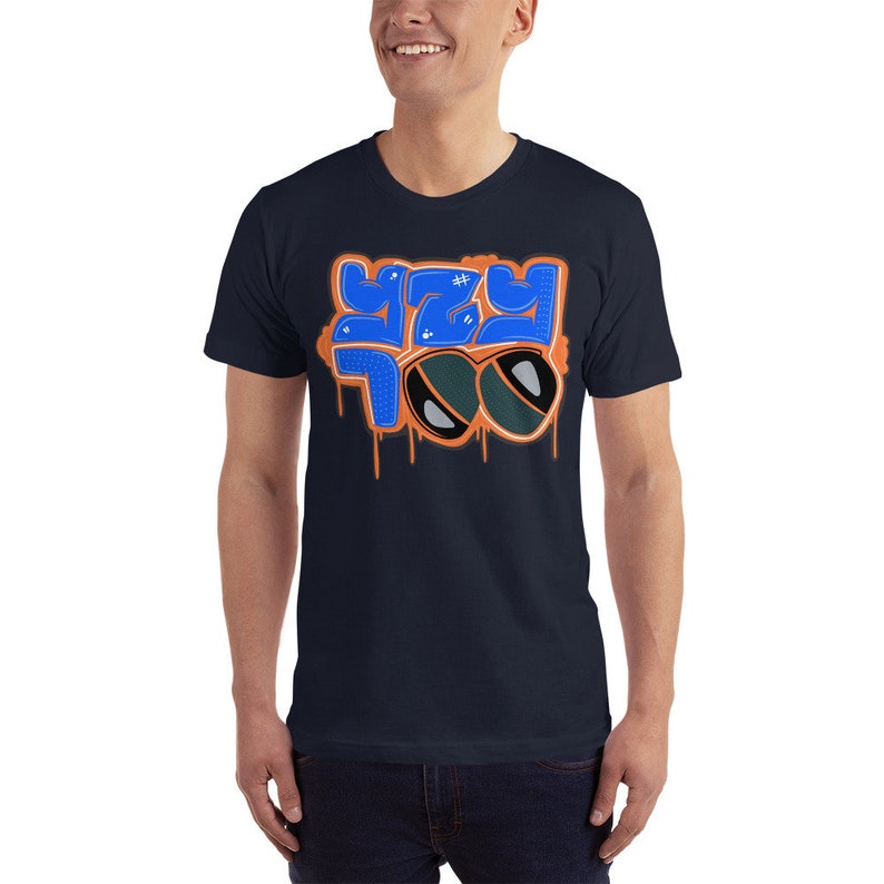 May include: A navy blue t-shirt with a blue and orange graphic design that says "Yey Too" with a pair of sunglasses.