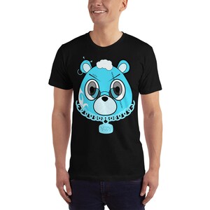 May include: A black t-shirt with a blue cartoon bear wearing a chain with a tag that says "YZY". The bear has stitches on its face and a white cloud on its head.