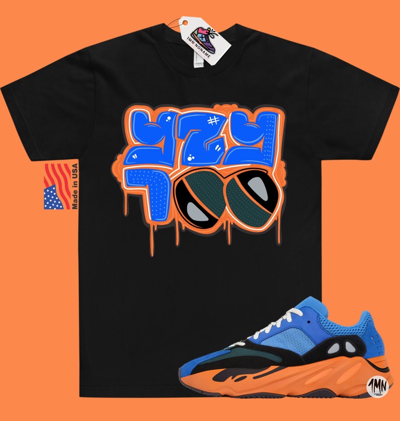 May include: Black t-shirt with a blue and orange graphic that says "YZY 700" with sunglasses.  A pair of blue and orange sneakers with a black sole.