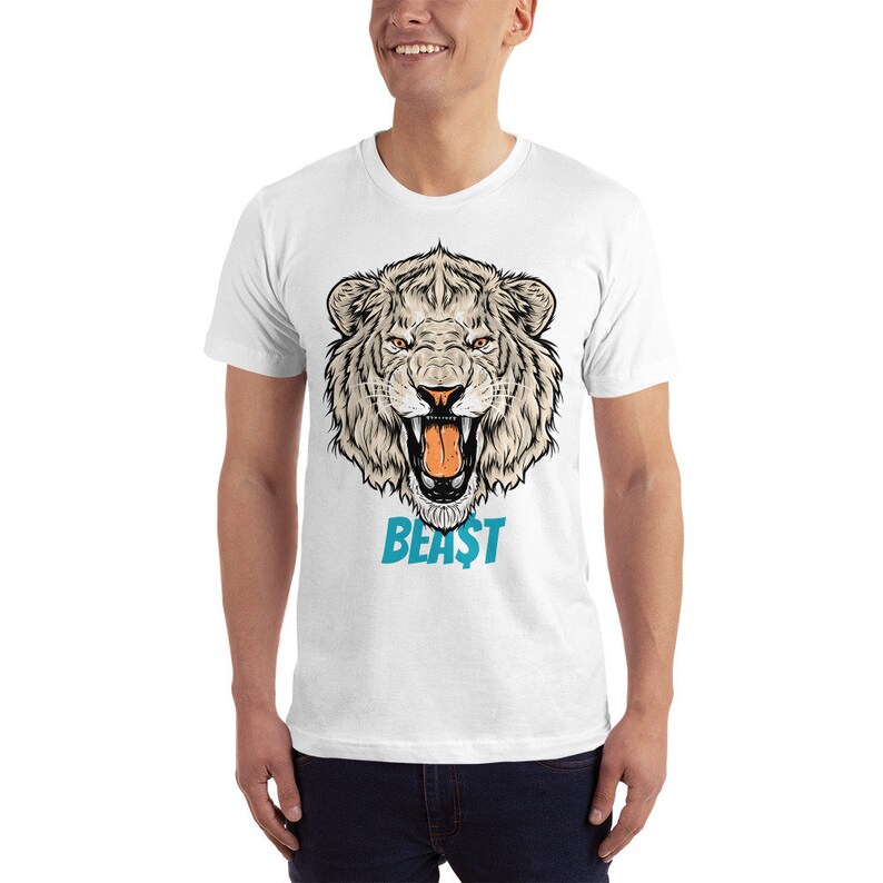 May include: White t-shirt featuring a detailed illustration of a tiger's head with an open mouth, showcasing its teeth. The word "BEAST" is printed in turquoise below the tiger's head. The design is centered on the shirt.