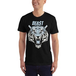 K&ouml;nnte beinhalten: Ein schwarzes T-Shirt mit einem wei&szlig;en Tiger-Motiv und dem Wort "BEAST" in blauer Schrift.