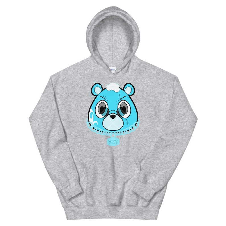 May include: A gray hoodie with a blue cartoon bear head wearing a chain with a YZY pendant. The bear has stitches on its face and a white cloud on its head.