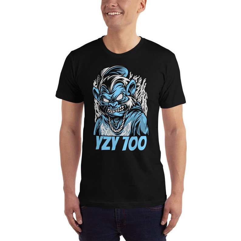 May include: Black t-shirt with a blue graphic of a cartoon monkey with flames behind it. The text "YZY 100" is printed in blue below the graphic.