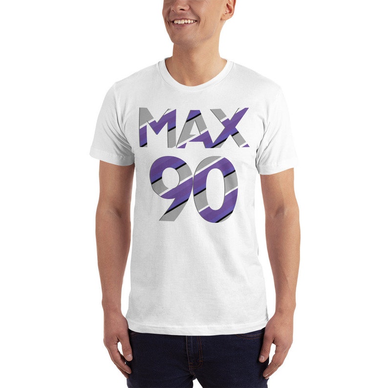 May include: White t-shirt with a purple and gray striped design that says "MAX 90" on the front.