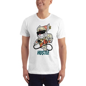 May include: White t-shirt featuring a cartoon rabbit wearing a hat, sunglasses, and holding a microphone. The rabbit is standing on an infinity symbol with the word "HU$TLE" beneath it.