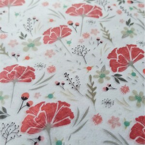 May include: A white background with a repeating pattern of red flowers and green leaves. The flowers have a watercolor effect and are slightly faded.