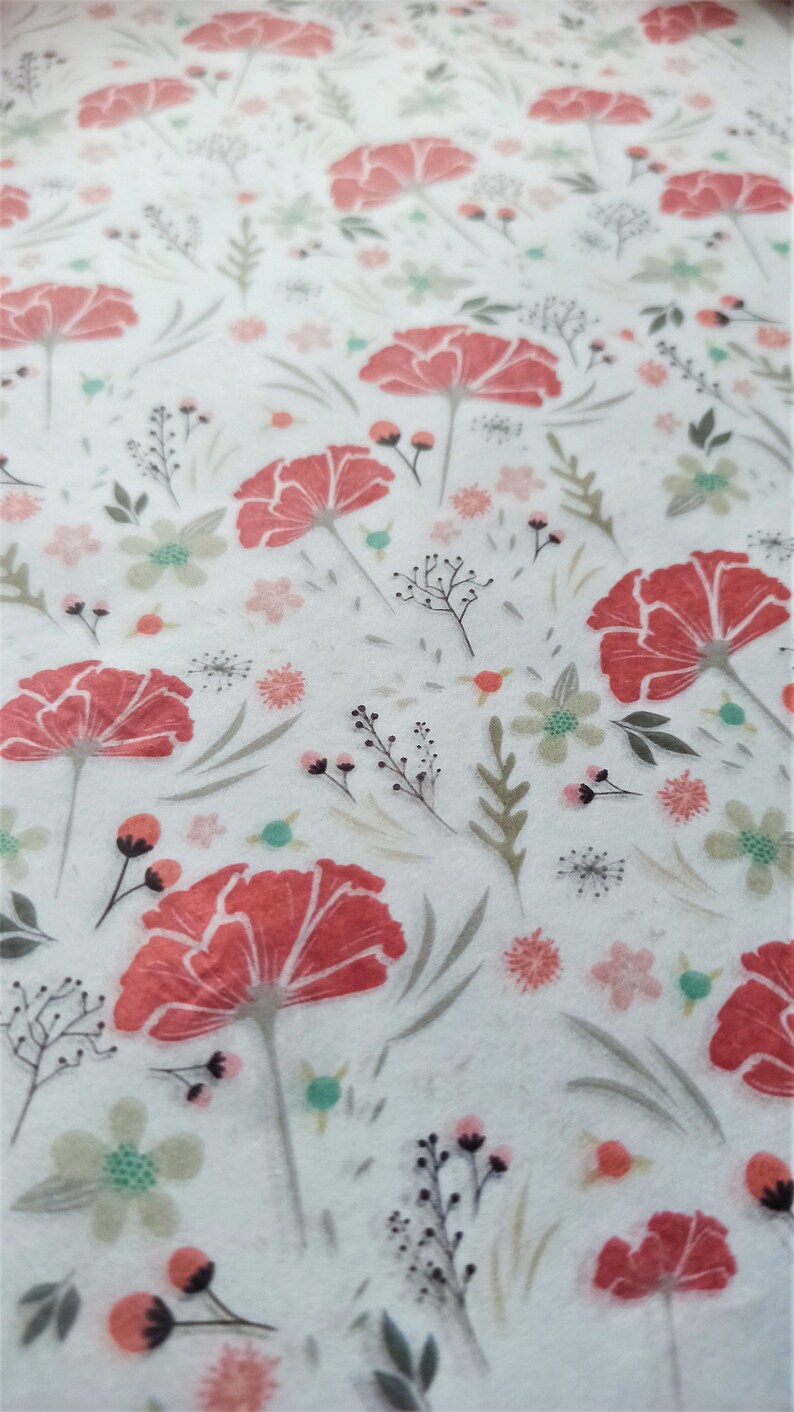 May include: A white background with a repeating pattern of red flowers and green leaves. The flowers have a watercolor effect and are slightly faded.