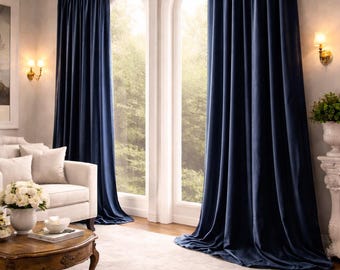 Puede incluir: Cortinas de terciopelo azul marino que van del suelo al techo, colgadas de una barra dorada sobre dos ventanas arqueadas. La tela pesada presenta pliegues verticales y cae hasta el suelo, creando una cubierta opaca y sólida.