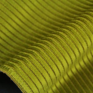 Chartreuse curled edge, ribbed velvet upholstery fabric close-up, pronounced parallel raised ribs