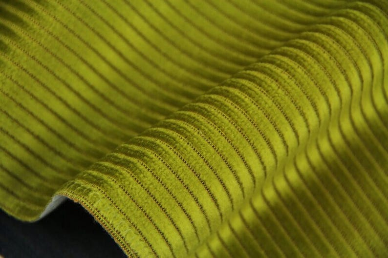 Chartreuse curled edge, ribbed velvet upholstery fabric close-up, pronounced parallel raised ribs