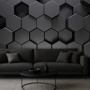 May include: A dark gray sofa with four cushions sits before a wall featuring a three-dimensional hexagonal pattern in shades of charcoal and black. A round black coffee table holds a small vase and bowl, while a lamp rests on a side table.