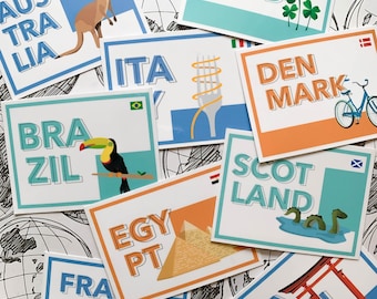 Puede incluir: Una colección de tarjetas coloridas con nombres de países e ilustraciones. Las tarjetas presentan un tucán, un canguro, un tenedor y un plato de espaguetis, una bicicleta, un monstruo del lago Ness, una pirámide, una puerta roja y un trébol.