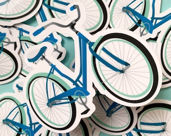 Puede incluir: Una pegatina de bicicleta azul y verde con ruedas blancas. La bicicleta tiene un manillar curvo y un asiento.