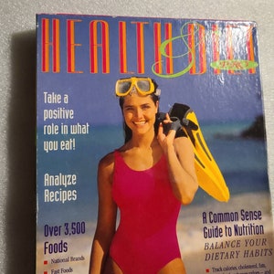May include: A book cover with a woman wearing a pink swimsuit and goggles holding yellow flippers. The title of the book is "Health & Diet" and the subtitle is "A Common Sense Guide to Nutrition". The book cover also includes the text "Take a positive role in what you eat! Analyze Recipes Over 3,500 Foods National Brands Fast Foods Balance Your Dietary Habits Track calories, cholesterol, fats, fiber, food exchange values - and"