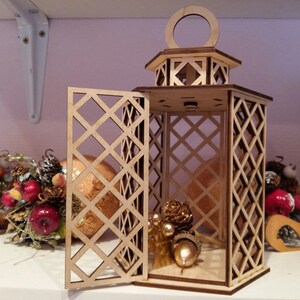 May include: A wooden lantern with a diamond-shaped lattice design. The lantern has a hinged door and a small opening at the top. The lantern is decorated with small, golden ornaments.