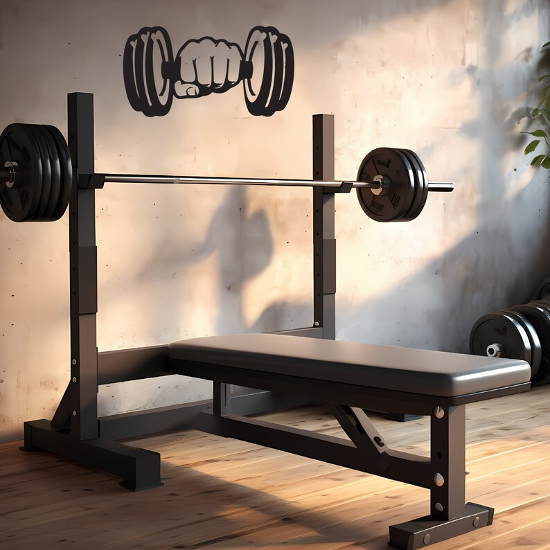 May include: A black weight bench with a barbell and weight plates. The bench is made of metal and has a padded seat. The barbell is resting on the weight rack, and the weight plates are stacked on the floor. There is a black dumbbell silhouette on the wall behind the bench.