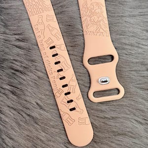 May include: A light peach-colored silicone watch band featuring laser-engraved designs including bottle shapes, an ear, and text that reads "AaahhHh", "Eat a bag of dicks Pony", and "PREPARE FOR SYATTLE!" with a graphic of a figure holding a torch.