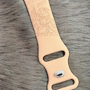 May include: A light peach-colored silicone watch band featuring an engraved illustration of a wizard holding a potion bottle. The text "PREPARE FOR BYATTLE!" is etched above and below the wizard figure. The band includes a silver metal pin.