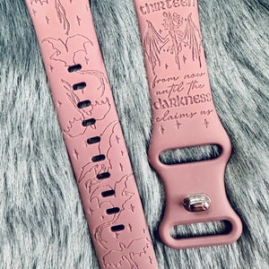 Puede incluir: Una banda de reloj Apple de silicona rosa con un diseño de una criatura alada y el texto "from the thirteen until the darkness claims us".