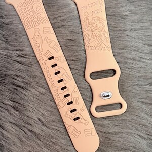 May include: A light peach-colored silicone watch band featuring engraved graphics of soda bottles, a character, and text that reads "Aaahhh", "Mommy's Special Boy", "PREPARE FOR BYATTLE!" with a silver metal pin closure on the shorter strap section.