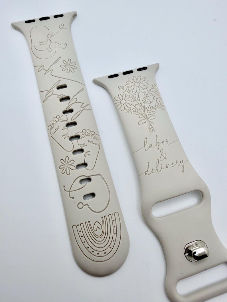 May include: A light beige silicone watch band featuring laser-engraved designs. One strap displays a fetus, baby footprints, a rainbow, and the text "oh baby". The other strap shows a bouquet of flowers and the text "labor & delivery".