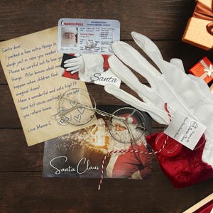 May include: A red velvet pouch with a red button and a white tag that says "Santa Claus" is on a wooden surface. There is a letter addressed to Santa, a pair of white gloves, a pair of round glasses, and a picture of Santa Claus holding a lantern.