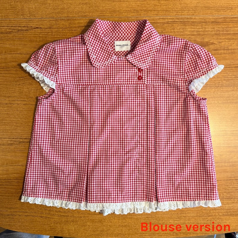 May include: A red and white gingham blouse with a Peter Pan collar and short sleeves. The blouse has white lace trim on the sleeves and hem. The label reads "MINA ZHAO". The words "Blouse version" are at the bottom.
