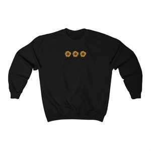 May include: Black sweatshirt with a row of three embroidered sunflowers in yellow and brown.