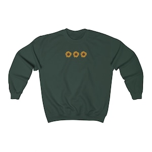 May include: A dark green sweatshirt with a row of three embroidered yellow sunflowers on the front.