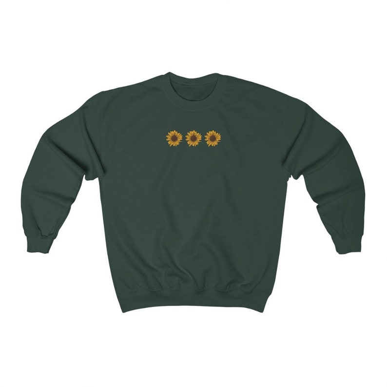 May include: A dark green sweatshirt with a row of three embroidered yellow sunflowers on the front.