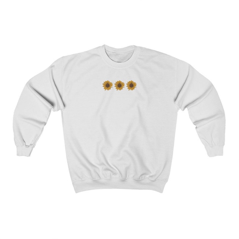 May include: White sweatshirt with a simple design of three yellow sunflowers in a row on the front.
