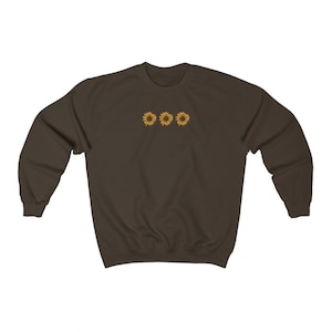 May include: A brown sweatshirt with three yellow sunflowers embroidered on the front.