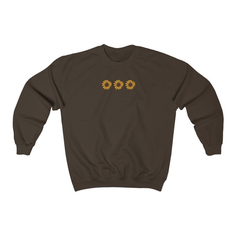 May include: A brown sweatshirt with three yellow sunflowers embroidered on the front.