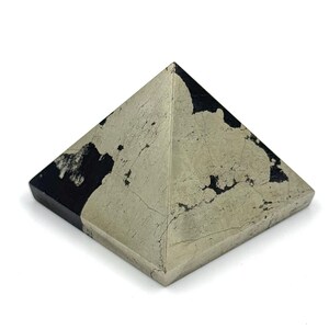 May include: A black and gold pyrite pyramid crystal. The crystal is a geometric shape with four triangular sides and a square base.
