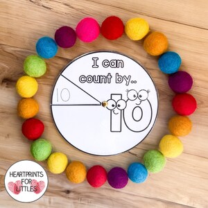 May include: A printable counting wheel with the number 10 and the text "I can count by..." surrounded by a circle of colorful felt balls.