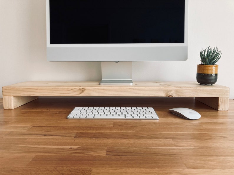 Pu&ograve; includere: Un supporto per monitor in legno con un monitor per computer, una tastiera e un mouse in cima. Il supporto &egrave; realizzato in legno naturale e ha un design semplice.
