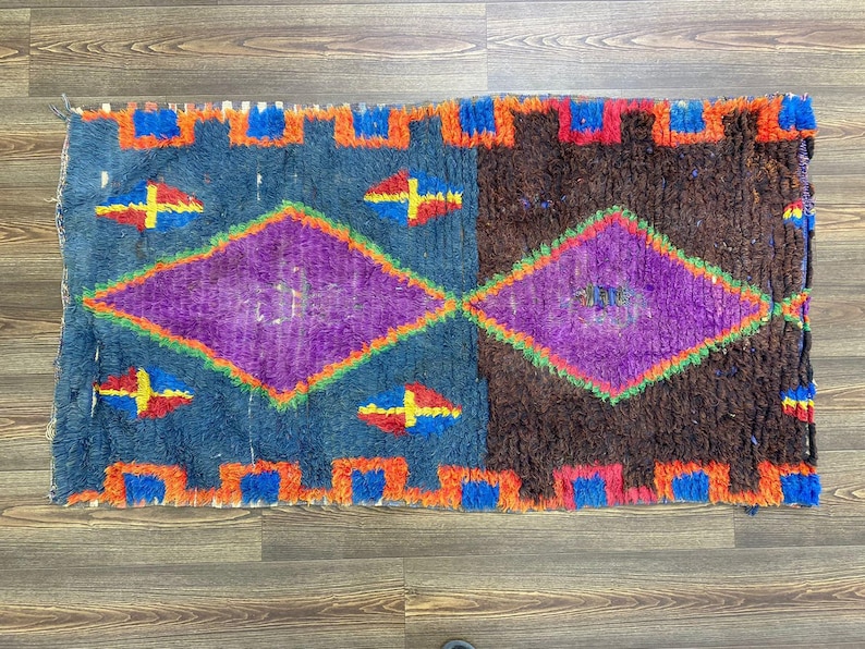 a vibrant, colorful rug with a geometric pattern in shades of blue, purple, and orange.