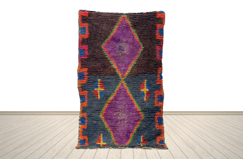 a vibrant, colorful rug with a diamond pattern and geometric shapes in shades of purple, orange, and blue.