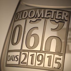 May include: A clear glass with an etched design that reads "Oldometer 060 DAYS 21915".