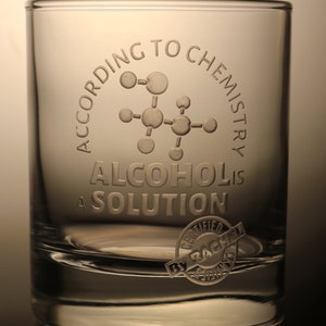 Könnte beinhalten: Ein klarer Glasbecher mit dem Text "Laut Chemie ist Alkohol eine Lösung" auf der Seite graviert. Der Text ist von einer chemischen Molekülgrafik umgeben. Ein kleiner runder Stempel mit dem Text "Zertifiziert von Rachel" befindet sich am Boden des Glases.