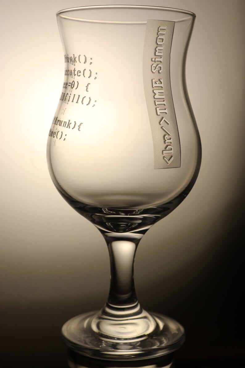 K&ouml;nnte beinhalten: Ein klares Glas mit breiter Basis und schmalem oberen Rand. Das Glas hat den Text "hink(); cute(); e=0) { fillo: Mrunk) { bre();" und "<br/>TIME Simon" auf der Seite eingraviert.