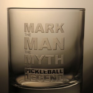 Può includere: Un bicchiere di vetro trasparente con la scritta "Mark the Man, the Myth, the Pickleball Legend" incisa sul lato.