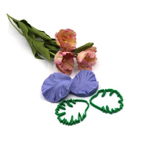 Può includere: Un set di stampi in silicone per realizzare petali e foglie di tulipano. Gli stampi sono viola e verdi e sono mostrati accanto a un mazzo di tulipani rosa.