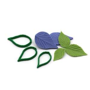 Könnte beinhalten: Ein Satz blattförmiger Silikonformen zum Backen und Dekorieren. Das Set enthält drei kleine grüne Blattformen und zwei größere Blattformen, eine blaue und eine grüne.