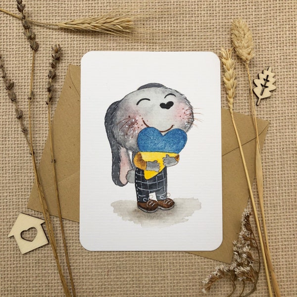 Postcard with a bunny hugging Ukrainian heart | Stand with Ukraine  | Hand-drawn watercolor postcard | 100% revenue goes to donation centers