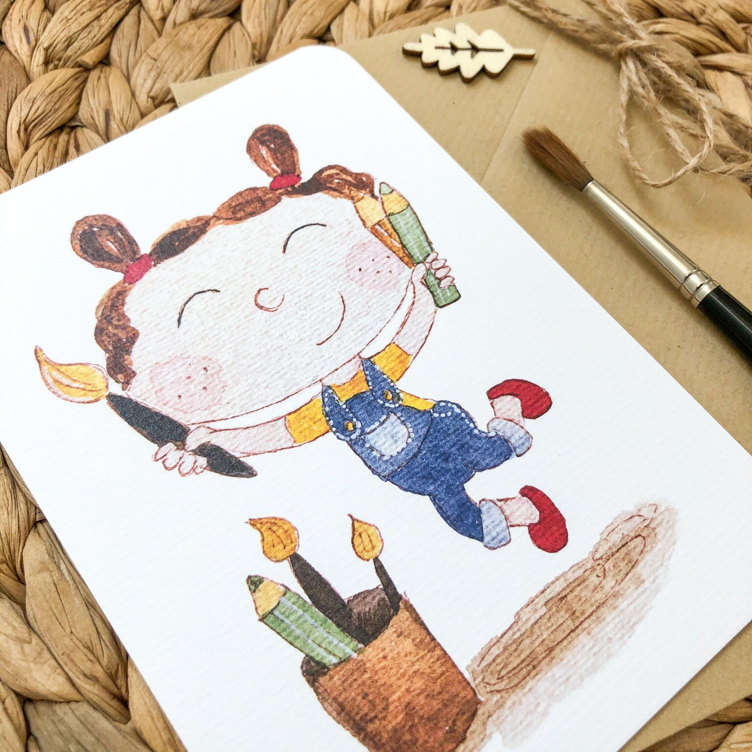 Hand-drawn postcard with a joyful girl jumping with a paint brush and colour pencils Hand-drawn postcard with a joyful girl jumping with a paint brush and colour pencils