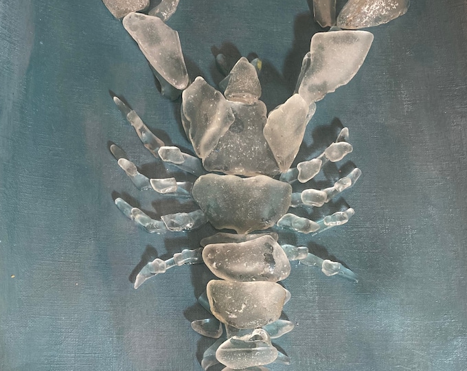 Sea Glass Lobster Wall Art with blue background in a white 11x14 shadow box frame.
