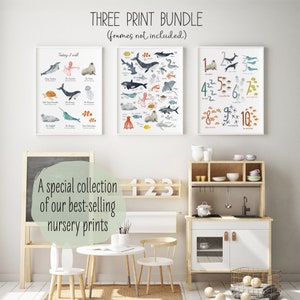 May include: Three watercolor prints featuring ocean animals and numbers. The prints are framed and displayed on a white wall in a playroom setting. The prints are titled "Today I well", "A-Z", and "1-10".